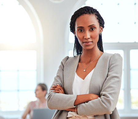 Portrait, African American woman and leader stand in office confident, relax and happy for successful business. Proud, female entrepreneur and black lady crossed arms, motivation and startup companyの写真素材