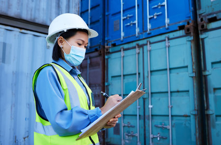 Covid, shipping logistics and employee writing during inspection at a container warehouse. Asian...