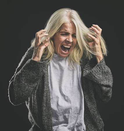 Frustrated, angry scream of elderly woman with mental health issue in retirement with mock up. Rage of senior lady suffering with anger, ptsd and depression problem in old age shouting.の写真素材