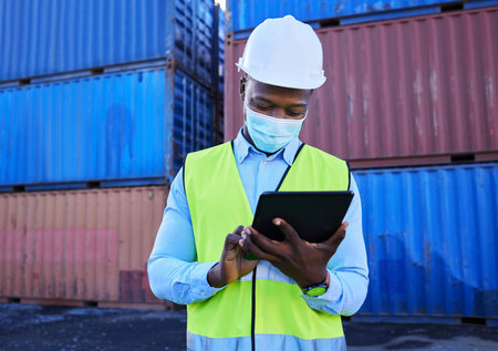 Tablet, logistics and worker with mask for covid safety working with digital checklist for international and global shipping. Cargo, container and supply chain delivery manager check schedule onlineの写真素材
