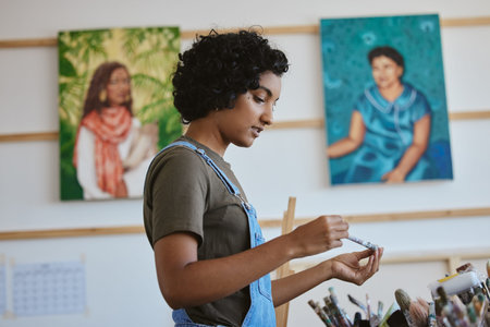 Creative, art and woman thinking in studio with choice of brush for next painting, artwork or design...