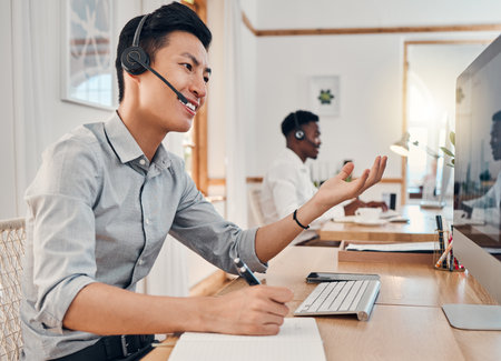 Consulting, call center and help with businessman at computer talking on phone call for customer support, telemarketing and sales. Communication, contact and inbound marketing with employee at deskの写真素材