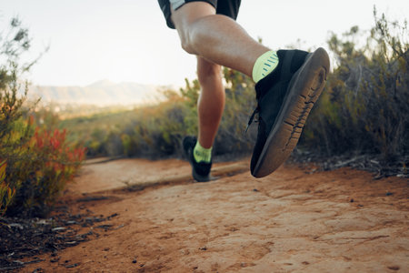 Fitness, shoes and runner in sports motivation for health exercise, workout and trekking in the nature outdoors. Shoe of active athlete in mountain running for healthy wellness and sport trainingの写真素材
