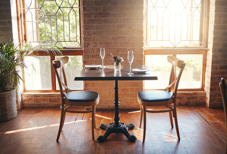 Empty room, glasses and table at a restaurant for a romantic date, celebration or luxury dinner. Wineglass for champagne, wine or alcohol beverage for a banquet, romance meal or elegant event.の写真素材