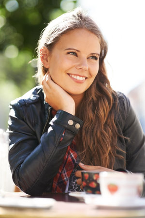 Relaxing at a local cafe. A beautiful teen sitting at a bistro with a cup of coffee.