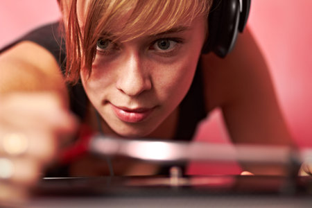 This is her passion. Closeup of a young female dj putting on a record.