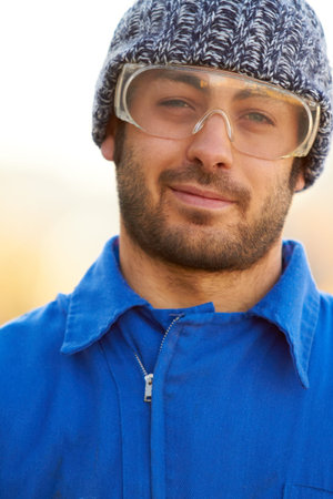 He takes precautions on the job. Portrait of a construction worker wearing protective glasses.
