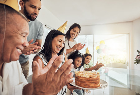 Family, happy and birthday with grandmother and celebration in dining room for party, love and cake. Smile, wow and event together with big family for surprise, excited and gift celebrate at homeの写真素材