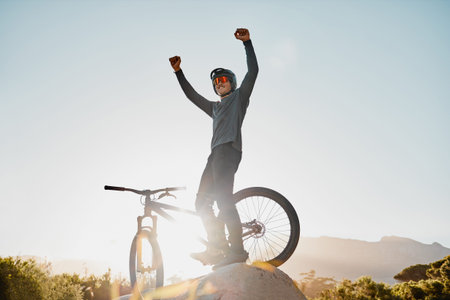 Mountain bike winner or motorcycle man with success, yes or fist pump for fitness achievement goal or motivation outdoor and blue sky mockup. Sports person winning with adventure bicycle on a hill