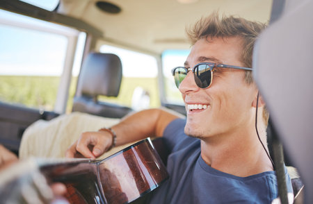 Music, guitar and young man in car on a roadtrip adventure in nature. Summer, holiday and journey on...