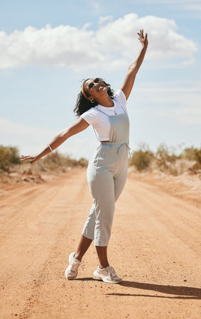 Freedom, nature and travel with a black woman on a sand road in the dessert during a summer holiday....