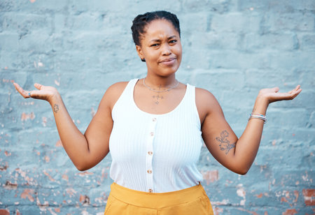 Portrait of confused black woman in doubt with a question and unsure gesture with arms up. Asking...