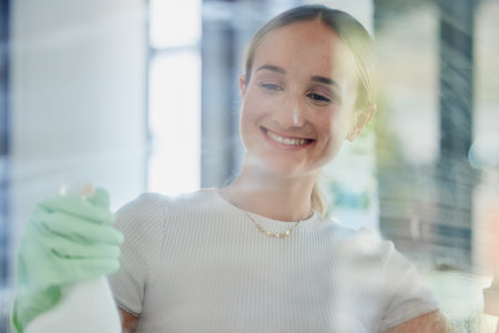Smile, home and woman cleaning window, housework or washing shower cabin. Hygiene, glass and happy female from Canada in rubber gloves, scrub and spring cleaning, sanitize for germ free living space.の写真素材