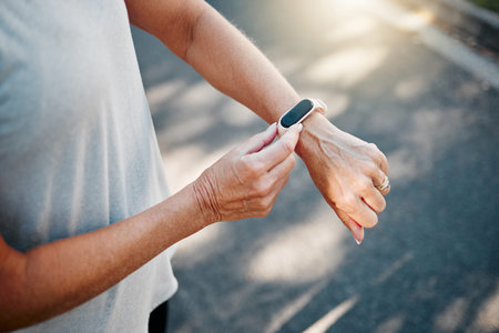 Senior woman, fitness runner with smartwatch for results, health and wellness on road exercise,...