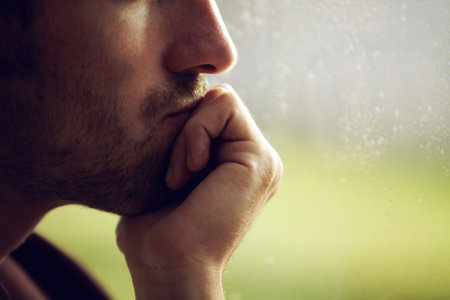 Hes deep in thought. Cropped image of a young mans face with his hand over his mouth.の写真素材