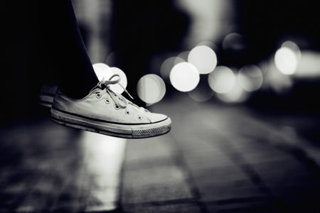 Hovering in the air. Cropped image of a person wearing sneakers appearing to hover over a street.の写真素材