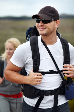 He loves the great outdoors. A happy young couple hiking with their backpacks.の写真素材