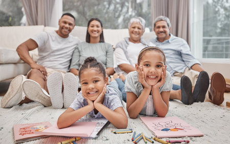 Two cute mixed race sibling sisters drawing and colouring in in the living room with their parents...