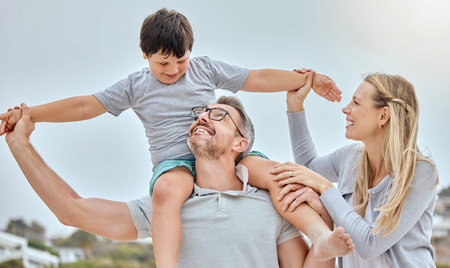 Happy caucasian family bonding together at the beach. Excited little boy sitting on his fathers...