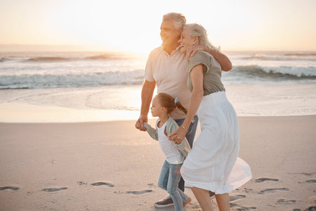 Mature couple strolling on the beach together. Happy senior grandparents walking with their...