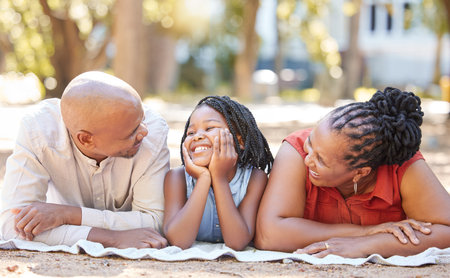 Happy african american family of three spending quality time together in the park during summer. Grandparents and granddaughter bonding together outside. Granny and grandpa out with their grandchildの写真素材