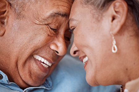 Love, couple and face of senior man and woman embracing and laughing, relax and bonding in their living room. Rest, happiness and retirement by caring soulmate share sweet moment, enjoy relationshipの写真素材