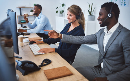 Happy caucasian female call centre telemarketing agent discussing plans with african american...