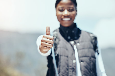 Thumbs up, hiking and woman travel success, motivation and support for outdoor adventure, happy exercise and healthy workout on mountain top. Closeup hands, freedom and wellness achievement in natureの写真素材