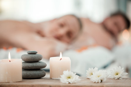 Background of aromatherapy candles, spa and couple luxury skincare, zen wellness and relax body at vacation salon. Closeup of massage stones, calm space and holistic beauty service for stress reliefの写真素材