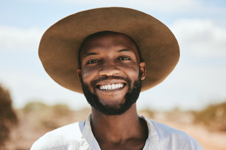 Portrait, black man smile and travel for holiday, vacation and on countryside outdoor. Happy face, young confident male and casual cool hat look relax, peaceful and on adventure for summer road trip.の写真素材