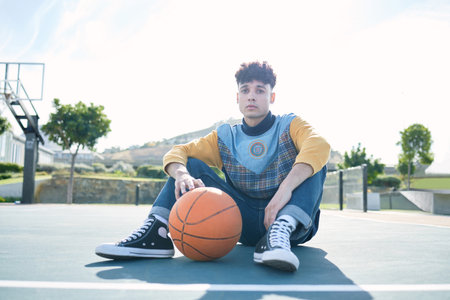 Man, basketball and training sitting on basketball court for rest, relax or breathe during practice. Basketball player, workout and sports for game in park for sport, fitness and physical healthの写真素材