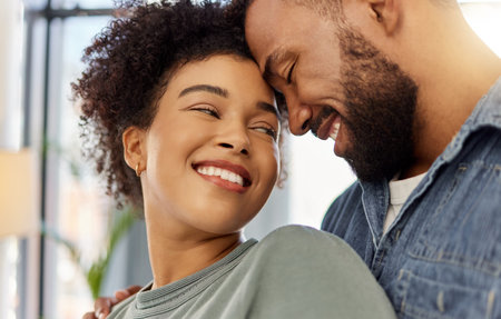 Happy mixed race girlfriend smiling while staring lovingly at her boyfriend. Carefree hispanic...