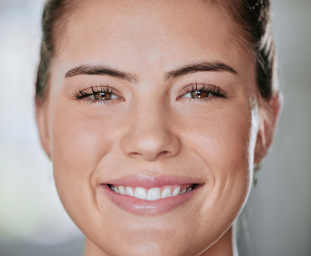 Closeup portrait of one smiling woman alone in gym. Headshot of beautiful happy caucasian trainer standing after workout in health club. Young coach in fitness centre for routine training and exercisの写真素材
