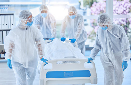 Biohazard team moving a dead body in a hospital bed. Team of doctors collecting a body dead from...