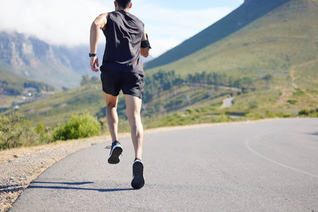 Running, fitness and exercise with a sports man and runner outdoor on a road in nature for training....