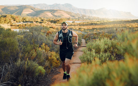 Runner, fitness or nature workout on mountains path, countryside landscape or sustainability environment. Sports man, athlete or running for health exercise, wellness workout or heart cardio trainingの写真素材