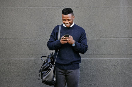 Businessman using his cellphone while walking in the city. Man using cellphone while commuting to work. Using internet while walking outside. Man using internet while commutingの写真素材