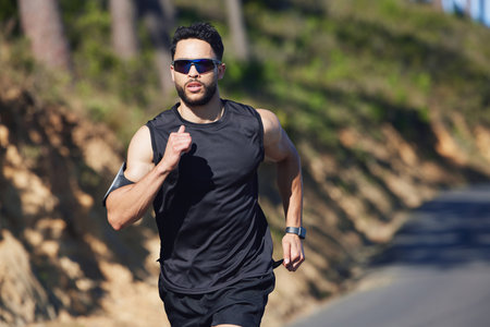Running, man and outdoor cardio fitness in nature for wellness, marathon training and healthy lifestyle in Dubai, UAE. Sports athlete, speed runner and morning exercise with sunglasses on summer roadの写真素材