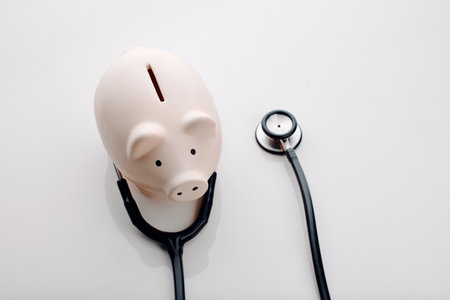 Good healthcare is expensive. High angle shot of a stethoscope around a piggybank in the studio.の写真素材