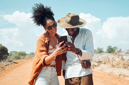 Black couple with phone, travel and adventure, happy outdoors in outback Australia during summer vacation. Romantic, bonding roadtrip and smile, search for map on mobile app or internet.の写真素材