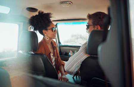 Happy, smile and couple in conversation while on road trip vacation with car in summer. Happiness, freedom and interracial man and woman on travel holiday, outdoor adventure or journey in countrysideの写真素材