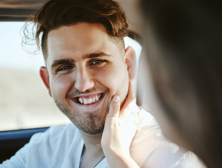 Couple, man and face touch in car with girlfriend for gratitude and care on road trip together. Woman touching cheek of happy boyfriend with real smile for intimate moment on travel journey.の写真素材