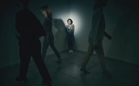 One mixed race female suffering mental illness in asylum. Hispanic woman experiencing a panic attack while being surrounded by people inside. Rape and Abuse victim feeling aloneの写真素材
