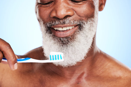 He looks forward to brushing his teeth. a handsome mature man posing in studio against a blue...