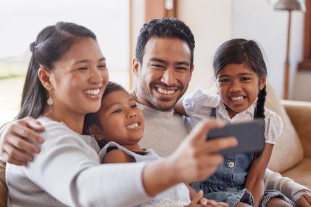 Lets take a selfie. an affectionate young family of four taking selfies on the sofa at home.