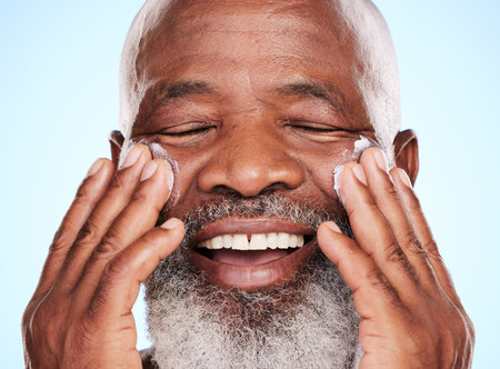 Who says men cant want soft skin. a handsome mature man posing in studio against a blue background.の写真素材