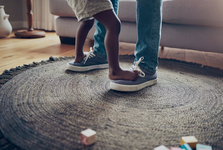 My first dance instructor. an unrecognizable parent and child dancing together at home.の写真素材