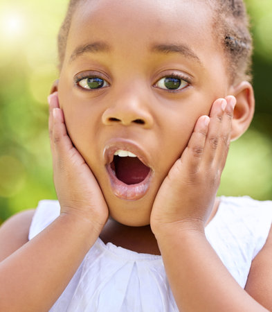What a surprise. a little girl looking surprised in nature.の写真素材