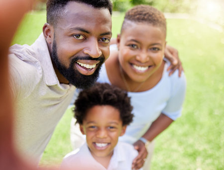 On the count of three, I want to see those big smiles. Portrait of a happy family taking selfies together outdoors.の写真素材