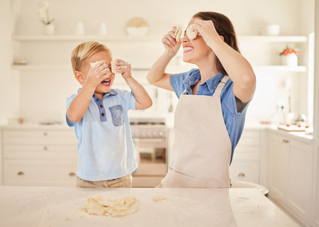 food can be fun. a mother and son playing with dough together while baking.の写真素材